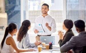 Staff, presentation and business man in a meeting, teamwork and planning with brainstorming, feedback and review. Presenter, group and team share ideas, collaboration and partnership with documents.