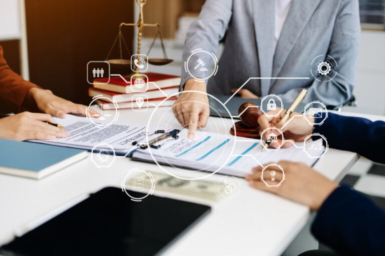 Business professionals reviewing a contract at a table with legal symbols and digital compliance icons representing employment law and workplace regulations.