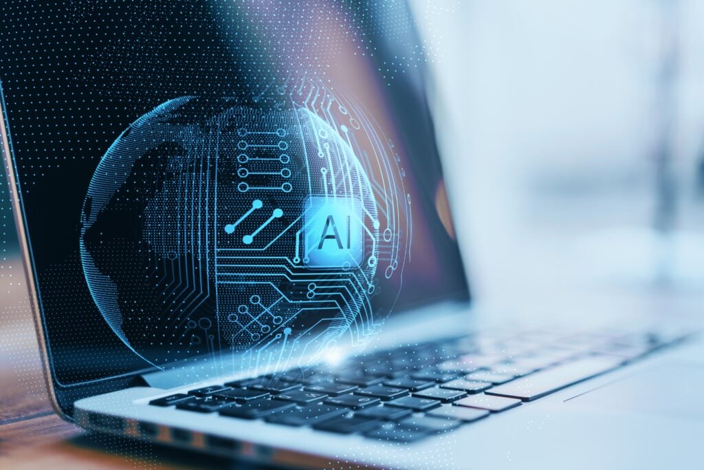 AI visualization of a glowing digital sphere with circuit patterns hovering above a laptop keyboard, representing artificial intelligence technology and data processing.